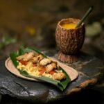 Delicious traditional Ecuadorian meal with a beverage served on a natural stone backdrop.